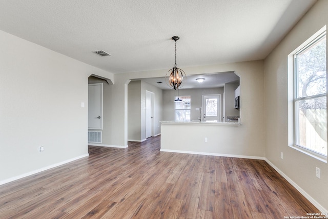 spare room featuring wood finished floors, visible vents, and a wealth of natural light