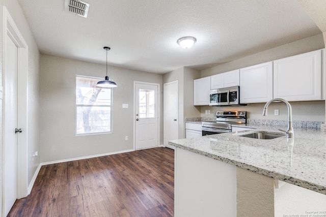 kitchen with visible vents, light stone countertops, appliances with stainless steel finishes, dark wood-style floors, and a sink