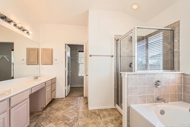 full bathroom featuring vaulted ceiling, double vanity, a wealth of natural light, and a sink