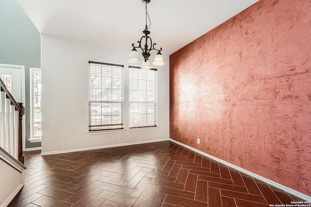 unfurnished dining area featuring baseboards, an inviting chandelier, and stairs