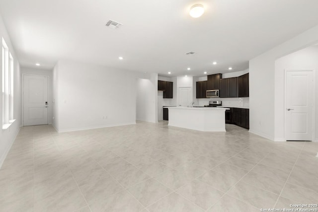 13210 Club House Blvd, San Antonio, TX 78221 - unfurnished living room featuring recessed lighting, baseboards, light tile patterned flooring, and a sink