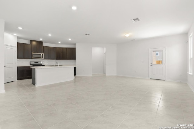 13210 Club House Blvd, San Antonio, TX 78221 - kitchen featuring appliances with stainless steel finishes, recessed lighting, light countertops, open floor plan, and dark brown cabinetry