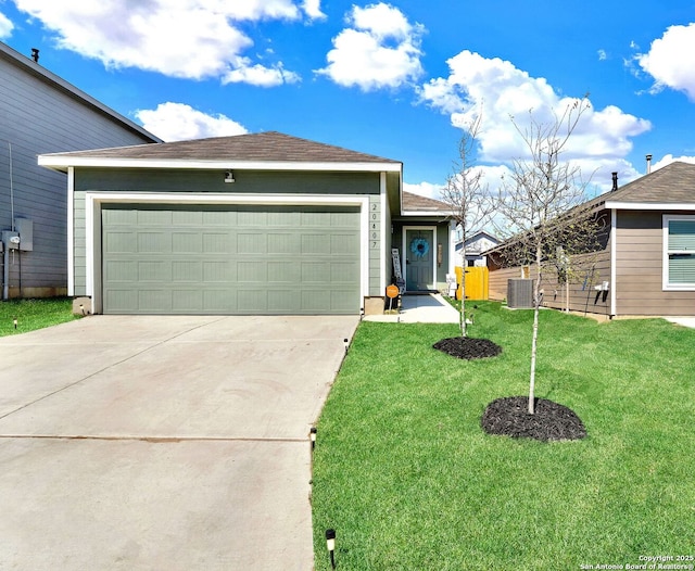 ranch-style home featuring central air condition unit, an attached garage, concrete driveway, and a front yard