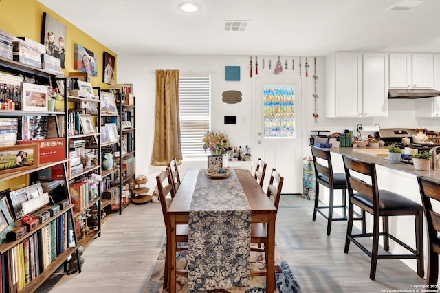 dining space featuring visible vents and light wood finished floors