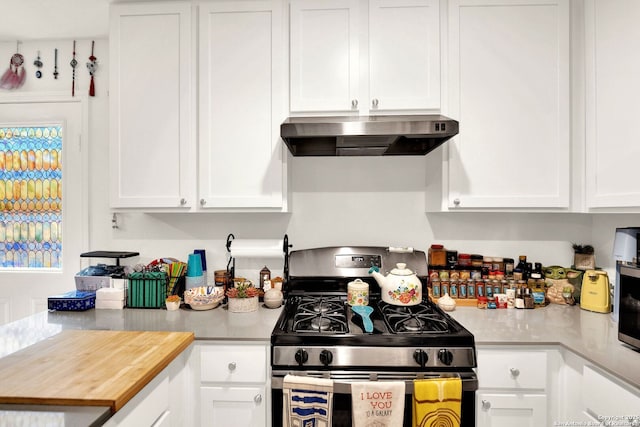 kitchen featuring ventilation hood, white cabinets, and gas stove