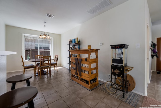 dining area with tile patterned floors, visible vents, baseboards, and a chandelier