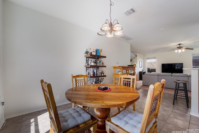 dining area with light tile patterned flooring, ceiling fan with notable chandelier, visible vents, and baseboards