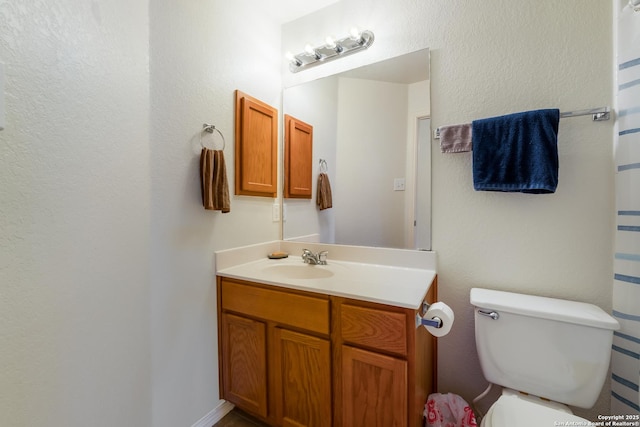 bathroom featuring toilet and vanity