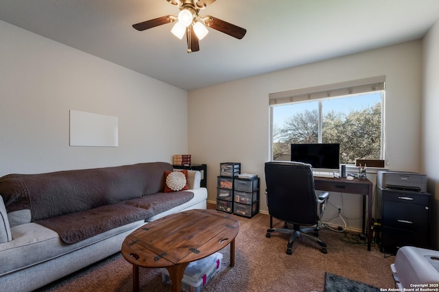 carpeted office with baseboards and a ceiling fan