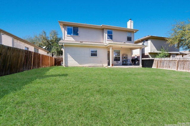 back of property featuring a patio, a lawn, a fenced backyard, and a chimney