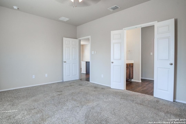 unfurnished bedroom featuring visible vents, baseboards, and dark colored carpet