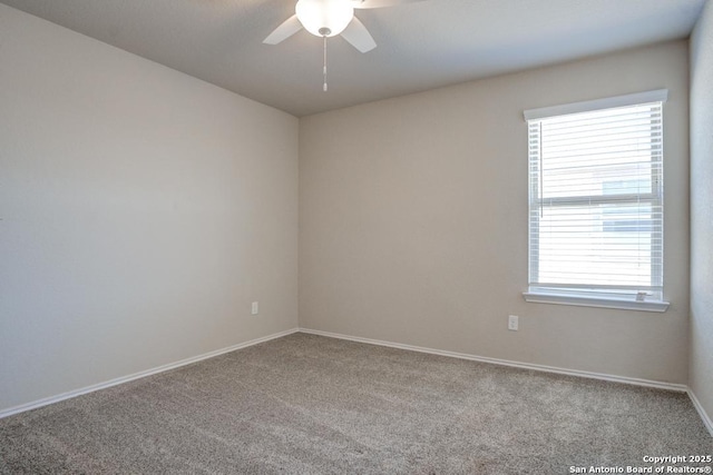 carpeted empty room featuring baseboards and ceiling fan