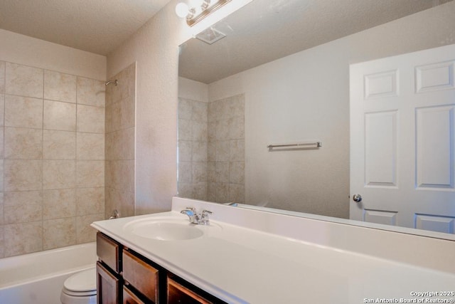 full bath featuring visible vents, toilet, a textured ceiling, washtub / shower combination, and vanity