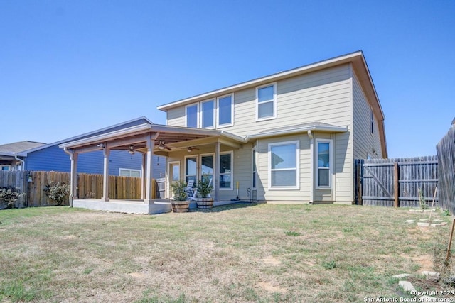 back of house with a fenced backyard, a patio area, a yard, and a ceiling fan