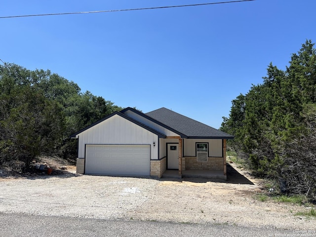 view of front facade with an attached garage and roof with shingles