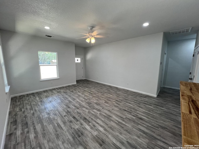 unfurnished living room with dark wood finished floors, baseboards, visible vents, and ceiling fan