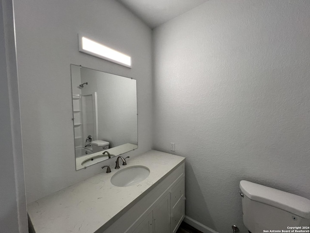 bathroom featuring shower / bathtub combination, toilet, vanity, and a textured wall