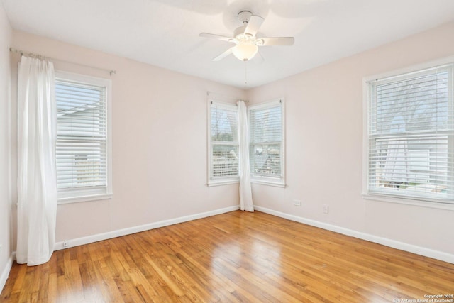 empty room featuring a ceiling fan, a healthy amount of sunlight, light wood-style floors, and baseboards