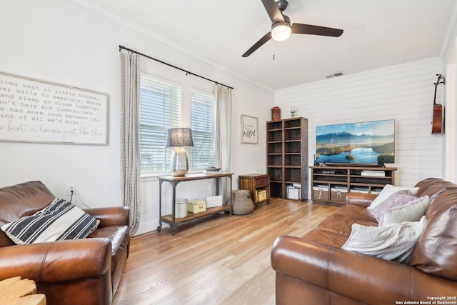 living area featuring visible vents, crown molding, ceiling fan, and wood finished floors