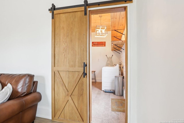 interior details with baseboards, washer / clothes dryer, and a barn door