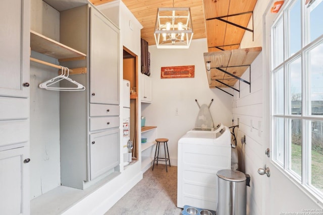 laundry area featuring a chandelier, cabinet space, wooden ceiling, and washer / clothes dryer