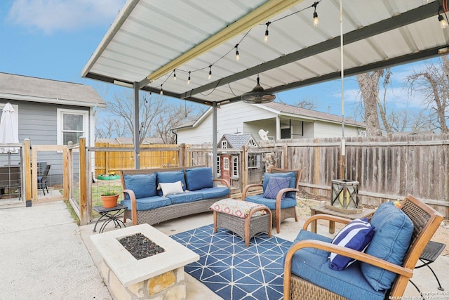 view of patio / terrace with an outdoor living space with a fire pit, a fenced backyard, and a ceiling fan