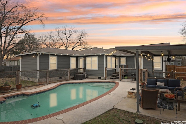 pool at dusk with a fenced in pool, an outdoor living space with a fire pit, a patio, and fence