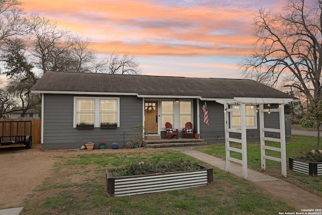 view of front of home with a shingled roof, a front lawn, and fence