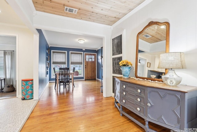 interior space featuring visible vents, light wood-style flooring, wooden ceiling, and ornamental molding