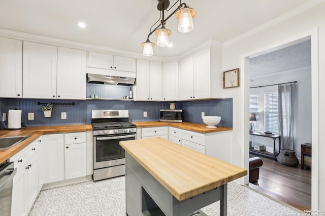 kitchen featuring under cabinet range hood, wood counters, tasteful backsplash, stainless steel appliances, and white cabinets