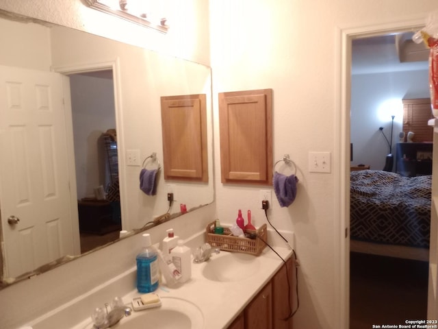 ensuite bathroom featuring ensuite bath, double vanity, and a sink