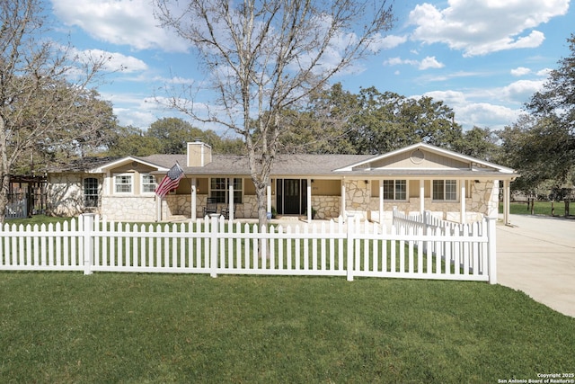 ranch-style home featuring a fenced front yard, a front yard, a chimney, stone siding, and driveway