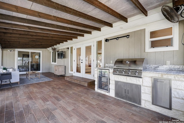 view of patio featuring french doors, wine cooler, area for grilling, and exterior kitchen