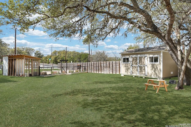 view of yard with an outbuilding, fence, and a shed