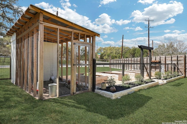 view of yard with an outbuilding, a garden, and fence