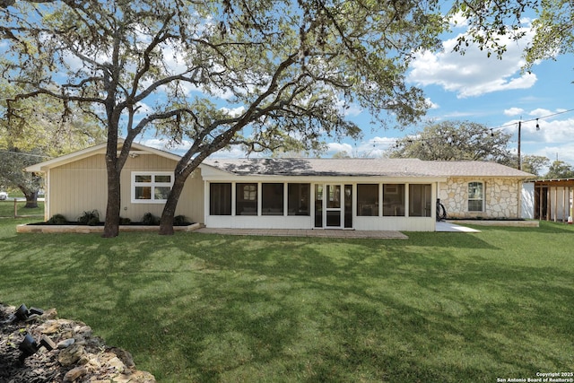 back of property featuring a yard and a sunroom