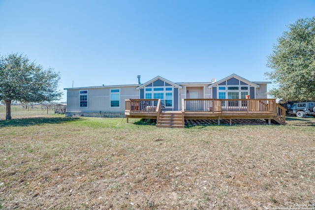 rear view of house with a wooden deck and a yard