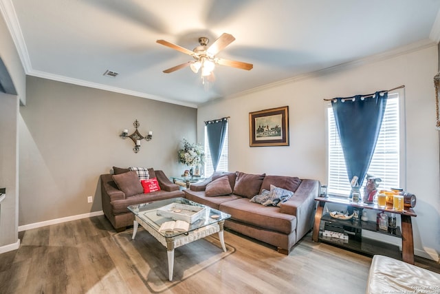 living area with visible vents, ornamental molding, a ceiling fan, wood finished floors, and baseboards