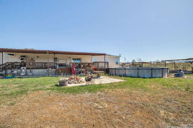 view of yard featuring a patio, an outdoor pool, and an outdoor fire pit