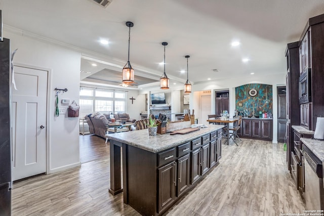 kitchen with dark brown cabinetry, pendant lighting, light wood-style flooring, and crown molding