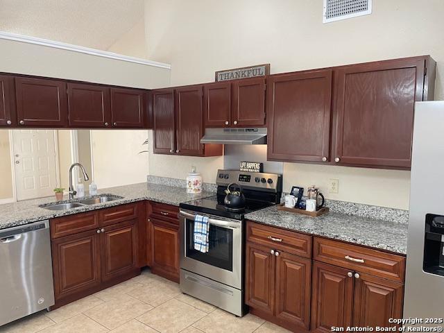 kitchen with visible vents, a sink, stone countertops, under cabinet range hood, and appliances with stainless steel finishes