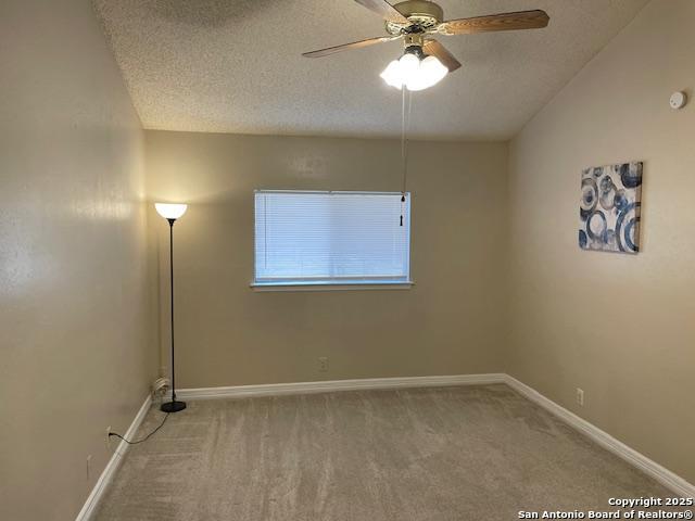 unfurnished room featuring ceiling fan, carpet flooring, baseboards, and a textured ceiling