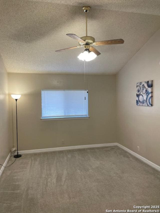 carpeted spare room with baseboards, a textured ceiling, lofted ceiling, and ceiling fan