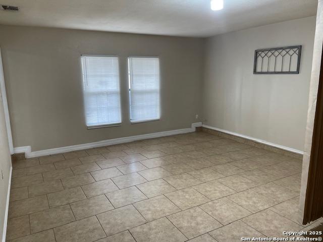 unfurnished room with visible vents and baseboards