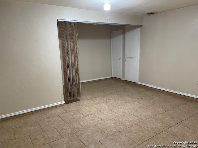 spare room with baseboards and visible vents