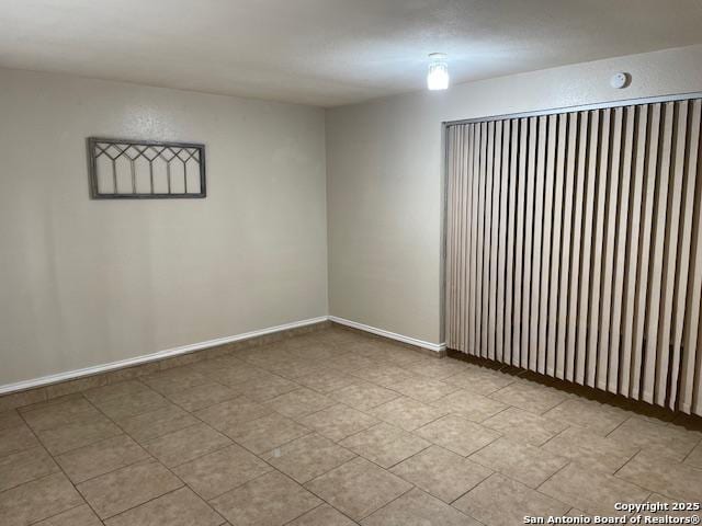 unfurnished room with baseboards