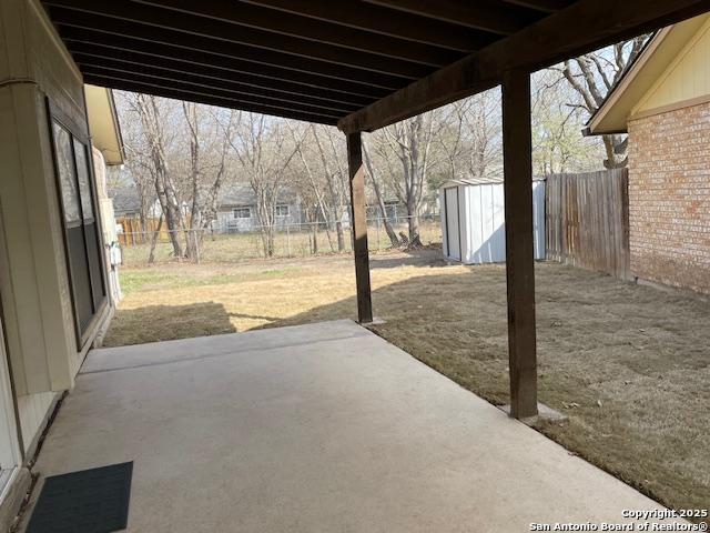 view of patio / terrace with an outbuilding, a shed, and a fenced backyard