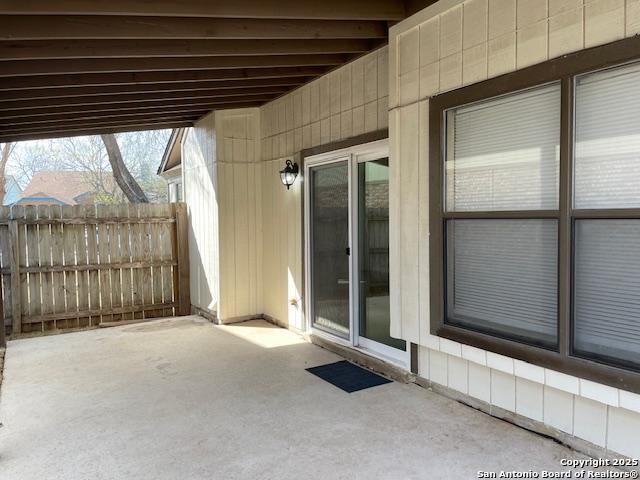 view of patio with a carport and fence