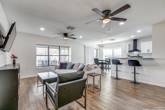 living room featuring recessed lighting, plenty of natural light, wood finished floors, and visible vents