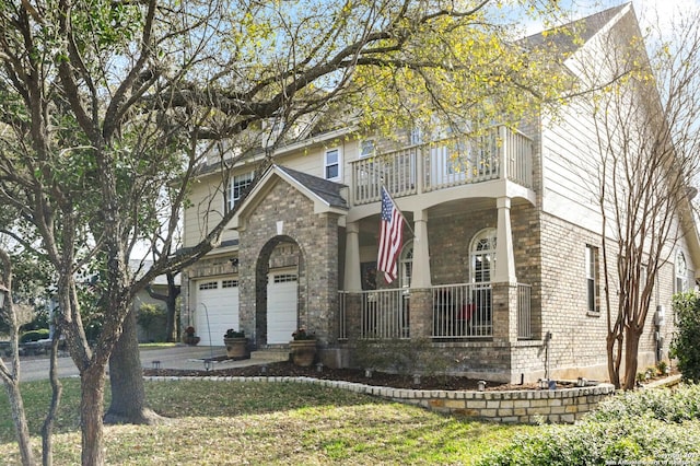 view of front of property with brick siding, a balcony, an attached garage, and driveway